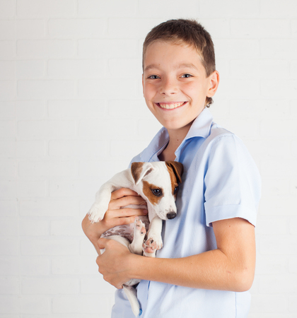 Boy with puppy. Teen with dog at homeの写真素材