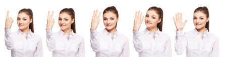 Woman at white background. Young female shows gesture. One, two, three, four, fiveの写真素材
