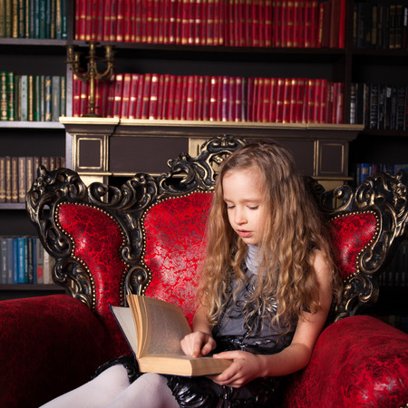 Girl reading book at home library
