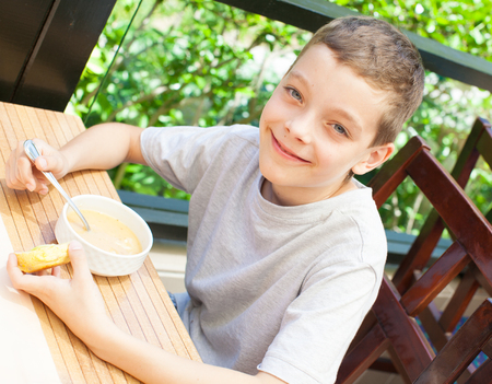 Child eating soup at cafeの写真素材