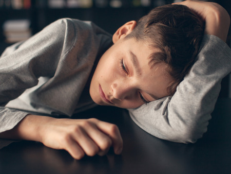 Sad boy. Depressed teenager at home. Problems at familyの写真素材