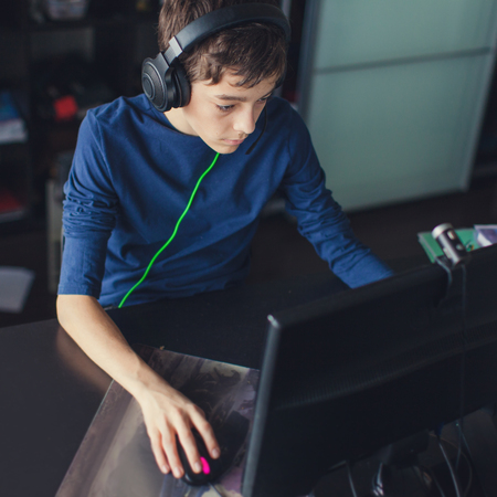 Teenager playing at computer game. Boy at homeの写真素材