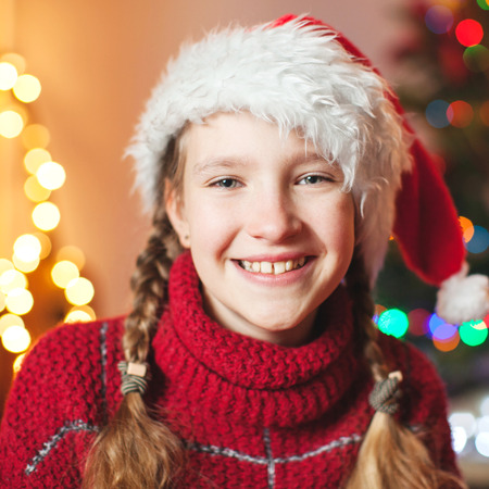 Smiling girl near christmas tree at home. Merry christmas and happy New year!の写真素材