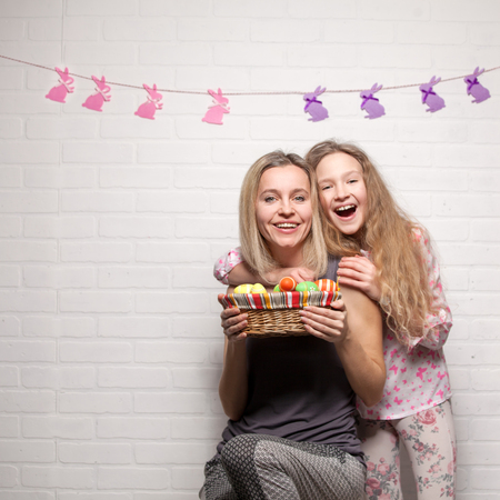 Happy adult woman and child with easter eggs. Family in an Easter suit with rabbit earsの写真素材