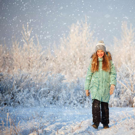 Child walking at winter park. Happy girl on snowの写真素材