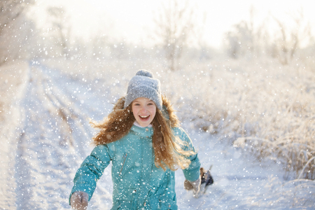Child walking at winter park. Happy girl on snowの写真素材