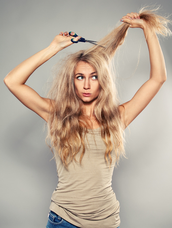 Young woman looking at split endsの写真素材