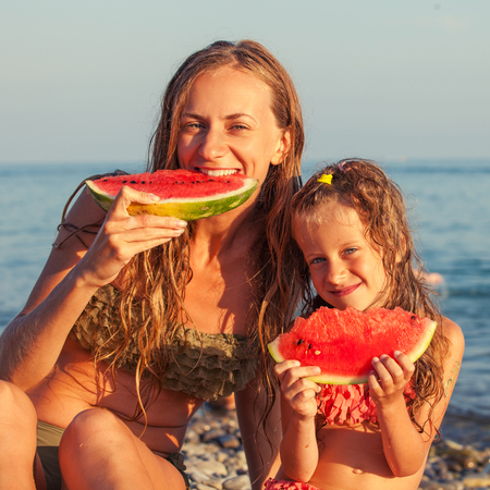 Child with mother eating watermelonの写真素材
