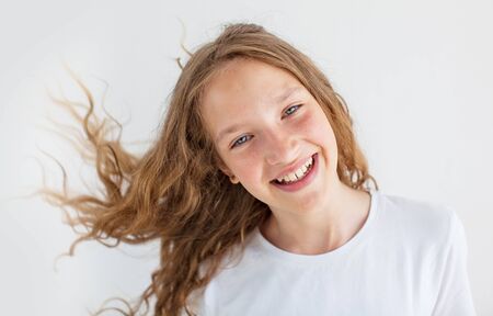 Portrait smiling young girl teen with flying curly hair
