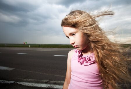 Sad girl near road. Child outdoorsの写真素材