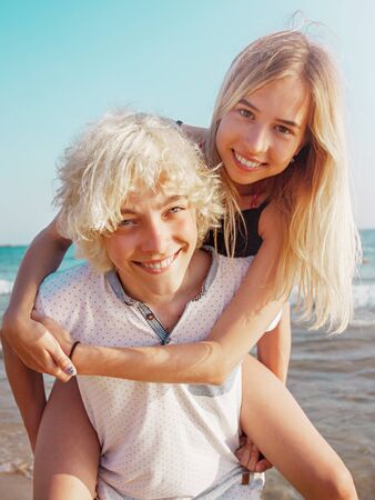 Happy young couple having fun at beach on sunny day. Smiling teens on vacationの写真素材