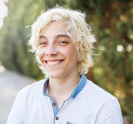 Happy teen outdoor. Smiling blond handsome boy