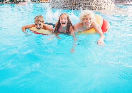 Children Having Fun In Outdoor Swimming Pool. Boy and girl in summer vacationの写真素材