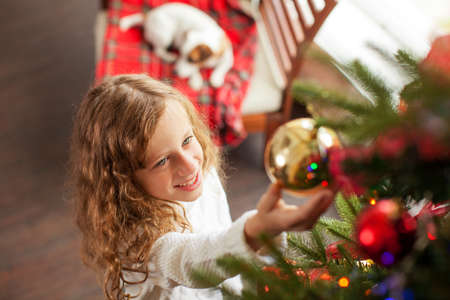 Child decoration christmas tree. Little girl at home. Happy New Year!の写真素材