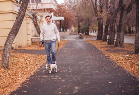 Man walks with his dog. Guy on the street with petの写真素材