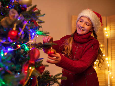 Child decoration christmas tree. Girl at homeの写真素材