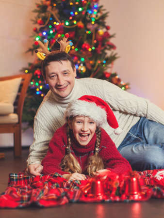 Child with dad near christmas tree at home. Merry christmas and happy New year!