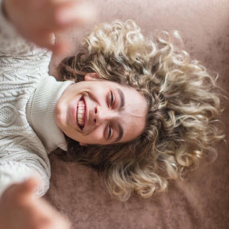 Laughing young man at home. Happy teen relax on sofa