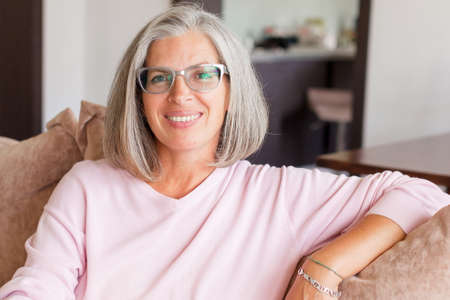Portrait of smiling mature woman with glasses looking at camera. Successful middle aged woman...