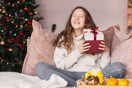 Happy Surprised teen girl holding her Christmas giftの写真素材