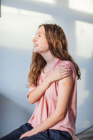 Vaccination of teenagers from covid-19, a young girl after inoculation in a medical hospital. Woman looking awayの写真素材