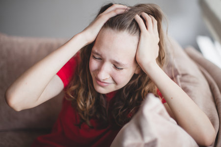 Expression of lonely female teenager at home. Portrait of a sad and crying teenage girl looking thoughtful about troubles. Pensive teen. Depression, teen depression, pain, suffering, stressの写真素材