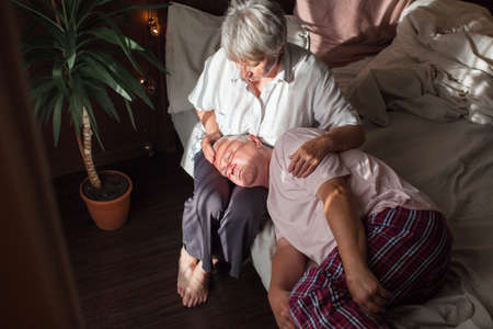 Worried middle aged woman embracing upset old man, side view head shot close up portrait. Sensitive mature wife showing support, comforting depressed elder husband, experiencing grief.の写真素材