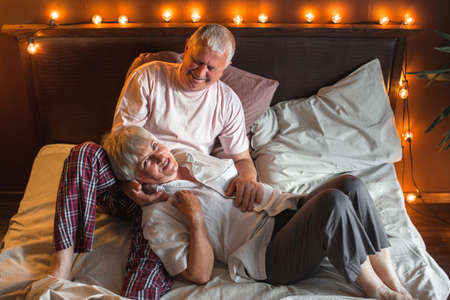 Feeling relaxed. Aged couple lying in bed and looking relaxed. seniors in bedroom at homeの写真素材