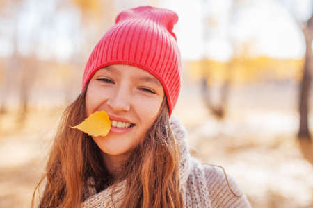 Portrait of funny young girl in the autumn weather in warm clothes and hatsの写真素材