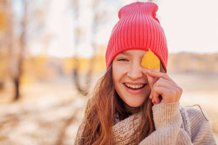 Young happy Woman with scarf and cap. Attractive teen girl wearing woolen clothes for autumn season . copy spaceの写真素材