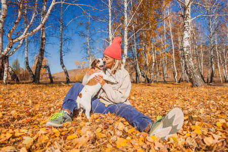 Middle aged happy Woman with scarf and cap. Attractive mature lady with dog wearing woolen clothes for autumnal seasonの写真素材