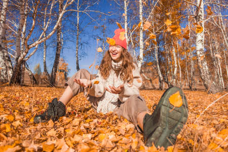 Young happy Woman with scarf and cap. Attractive teen girl wearing woolen clothes for autumnal seasonの写真素材