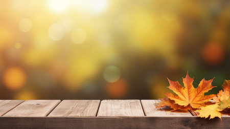Wooden table with autumn leaves against a blurred backgroundの素材