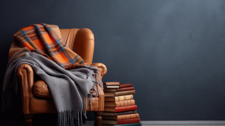 A cozy leather armchair draped with a plaid blanket next to a stack of booksの素材