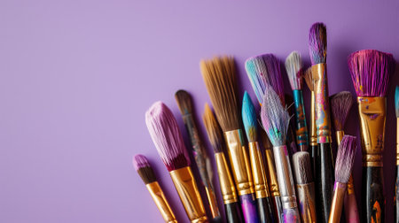 A collection of various paintbrushes against a purple backgroundの素材