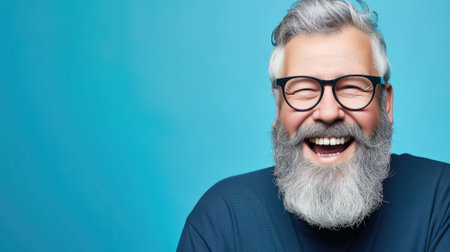 Portrait of a bearded man with glasses laughing heartilyの素材