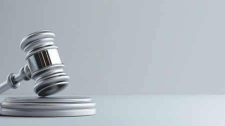 Silver gavel lying on reflective surface, symbolizing law and justiceの素材