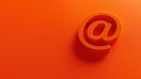 3D at symbol in metallic red against orange backgroundの素材