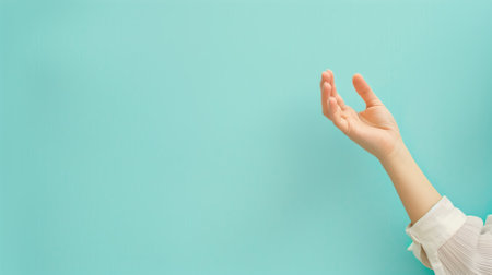 Human hand positioned as if holding object against plain blue backgroundの素材
