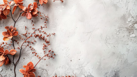 Orange flowers and berries on light textured surface, creating autumnal aestheticの素材