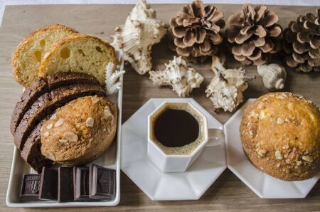 Coffee in a white cup with chocolate and pastries