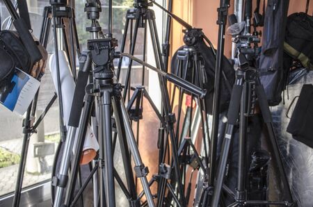 Different tripods for cameras and reflector by the windowの写真素材