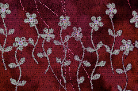 Pattern of stylized white wild flowers with stems and leaves on an red burgundy mosaic backgroundの写真素材