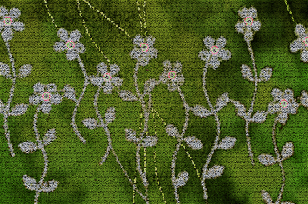 Pattern of stylized white wild flowers with stems and leaves on an green mosaic backgroundの写真素材