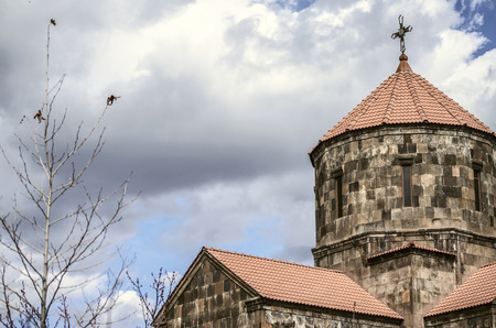 Yerevan; Armenia; the community Nerkin Charbakh; 2 February; 2018: Storm clouds over the dome in the form of an umbrella covered with red tiles with forged cross  in the Church of the Holy Cross in the suburbs of the capital of Armeniaの写真素材