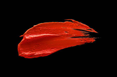 Orange lipstick smudged on a black isolated backgroundの写真素材