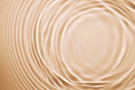 Orange splashing cosmetic moisturizer, micellar water, toner, or emulsion backgroundの写真素材