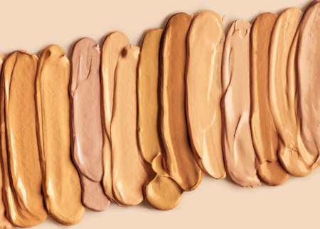 Palette of different shades make up foundation drop smudge texture beige isolated background