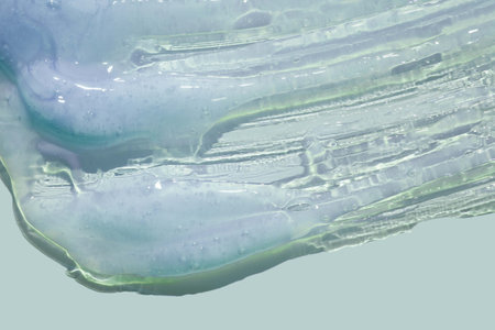 Transparent liquid soap with bubbles on a light blue background. Close-up.の写真素材