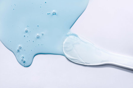 Blue paint dripping from a spoon on white background. Top view.の写真素材